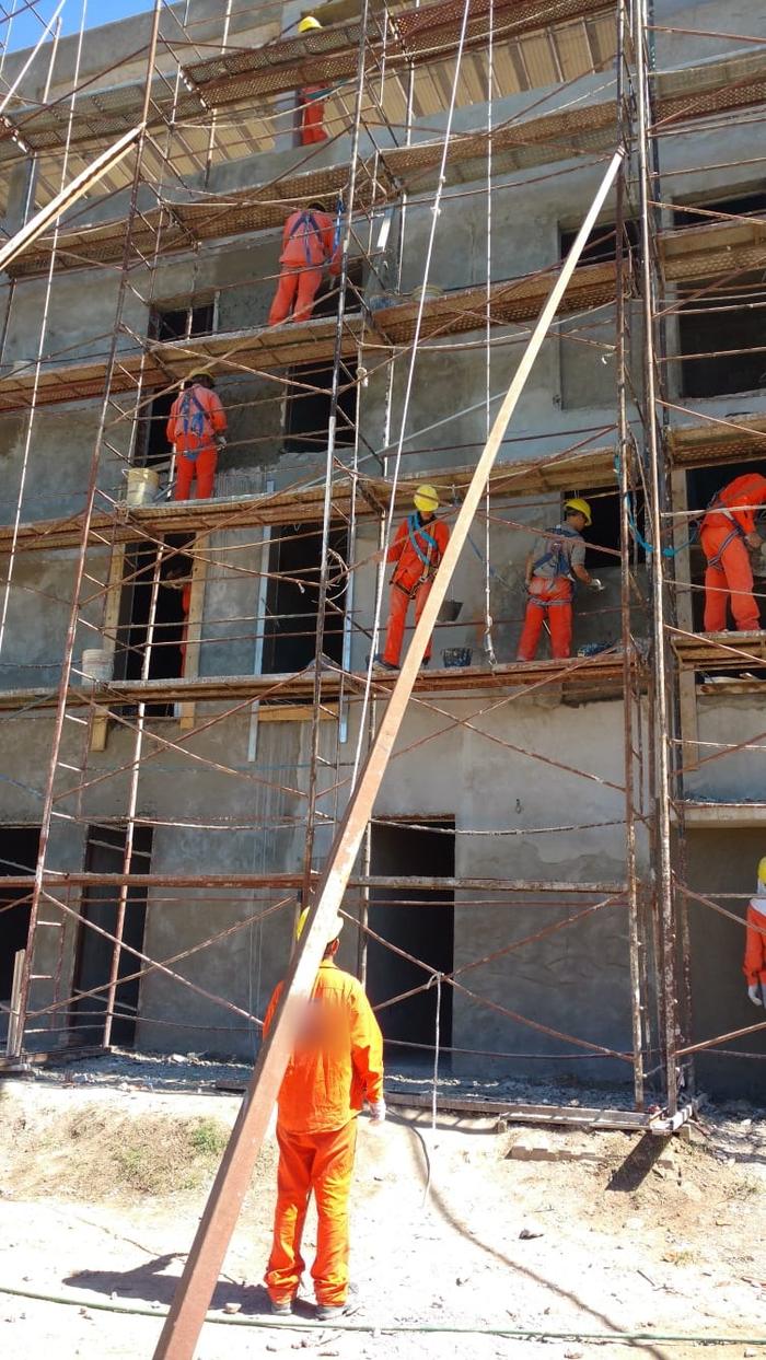 Operarios con arnés trabajando en andamios